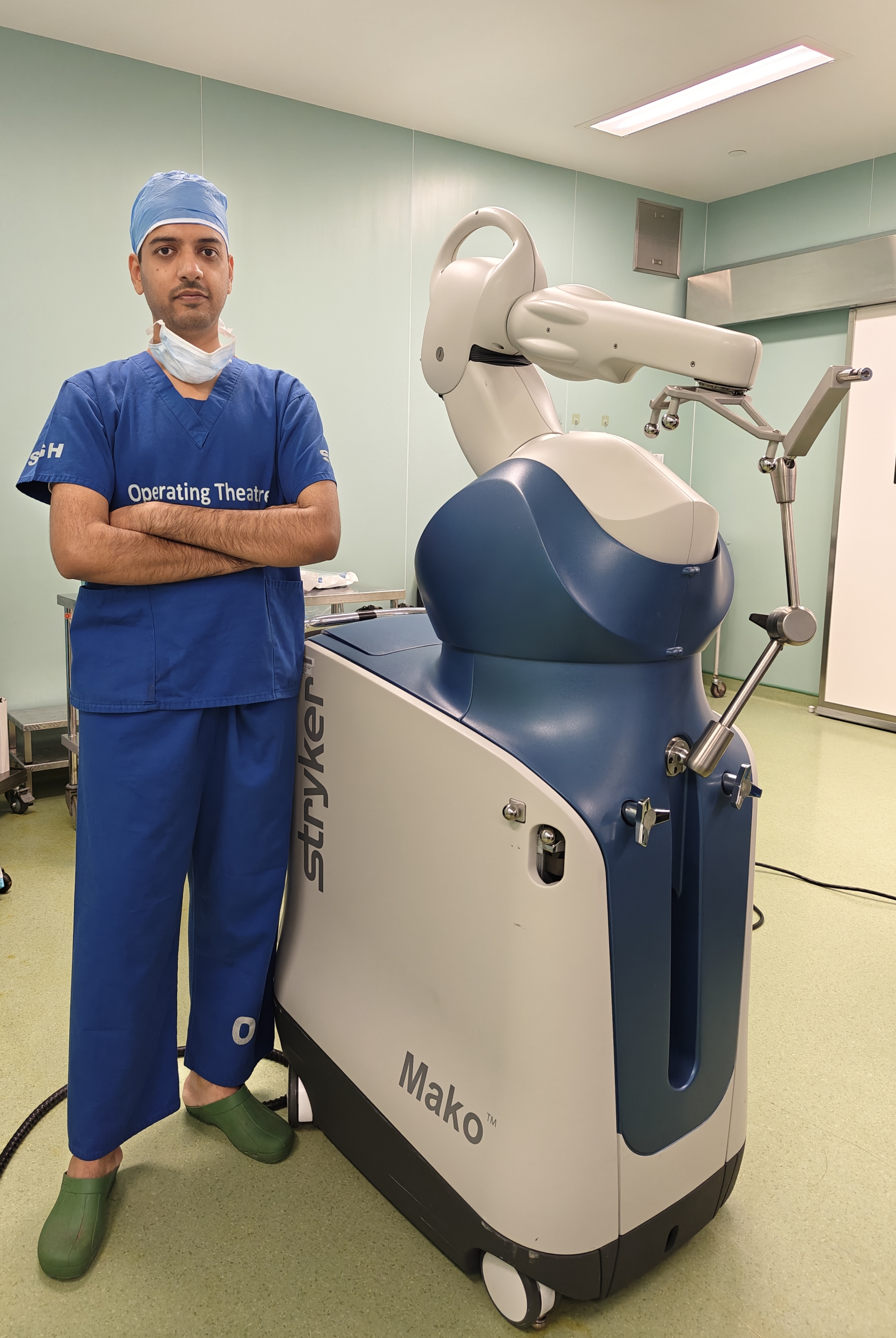 Dr. Mohammed Shahid beside a MAKO robotic-assisted joint replacement system